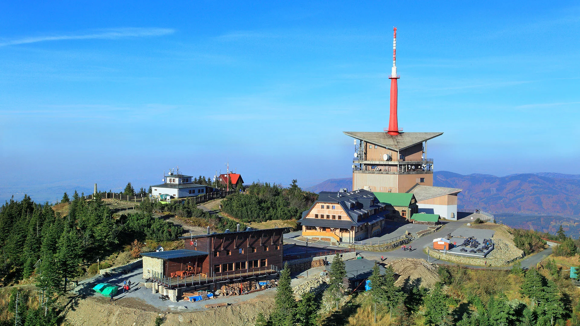 Summit of Lysá hora with stone lookout tower and tourists